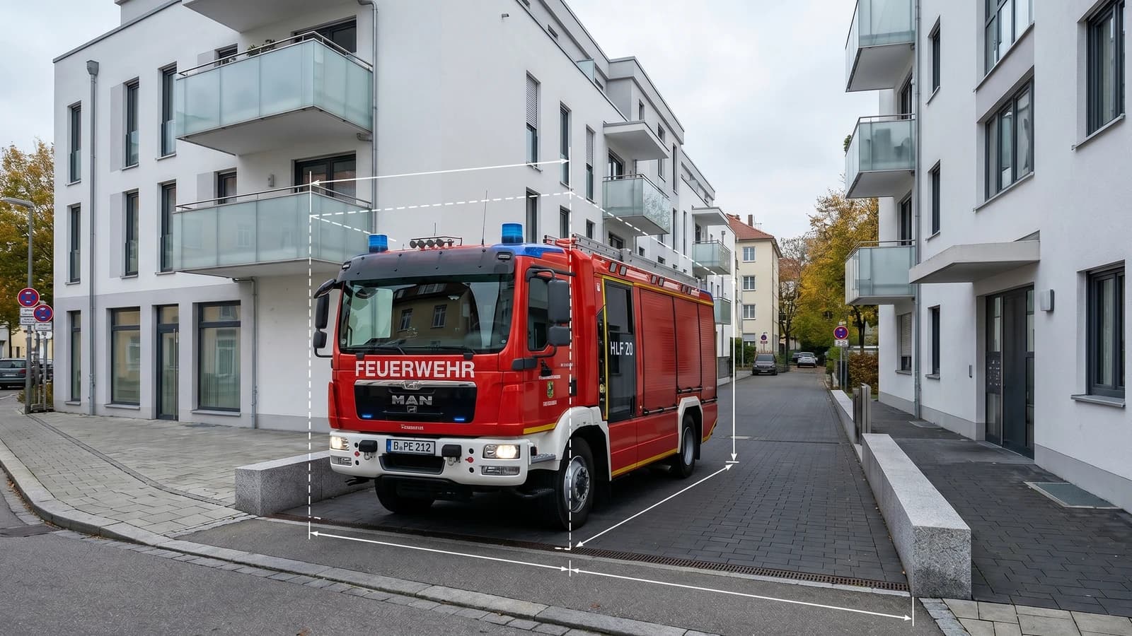 Feuerwehrfahrzeug bei der Anfahrt durch eine schmale Zufahrt zwischen modernen Wohngebäuden
